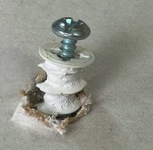 a failed fixing that has pulled out of the plasterboard leaving a messy hole